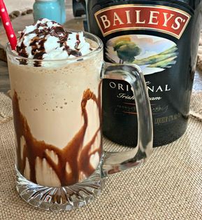 there is a drink with ice cream and chocolate on the table next to a bottle