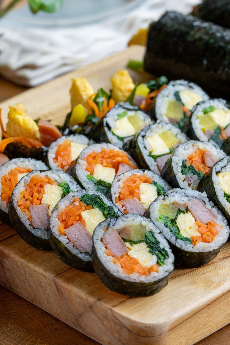 several sushi rolls on a wooden cutting board