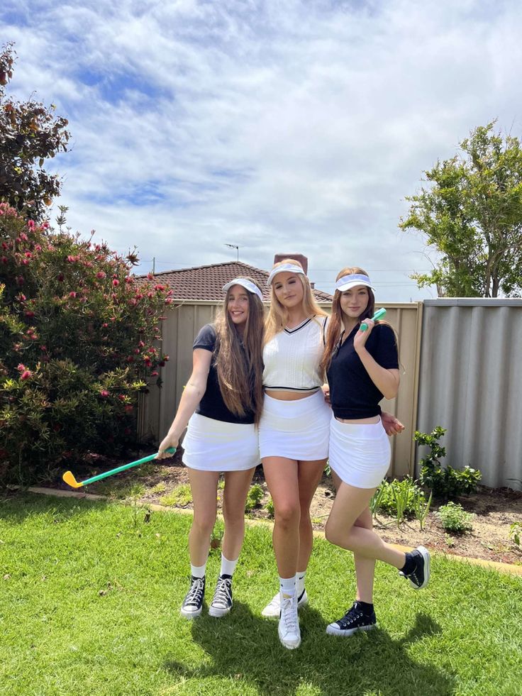 three girls in tennis outfits posing for the camera