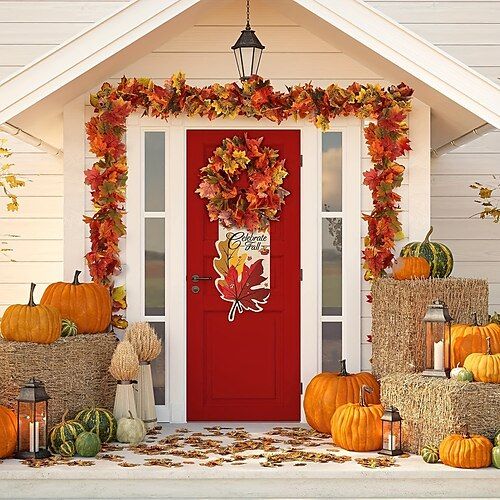 a red door surrounded by pumpkins and hay bales with fall decorations around it