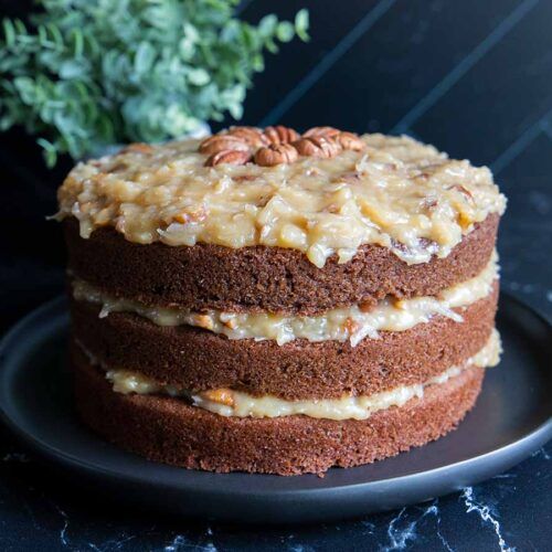 a cake with nuts on top sitting on a plate