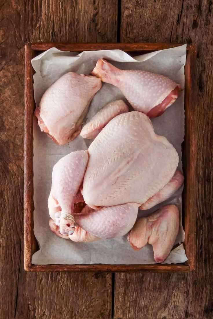 raw chicken in a wooden box on a table