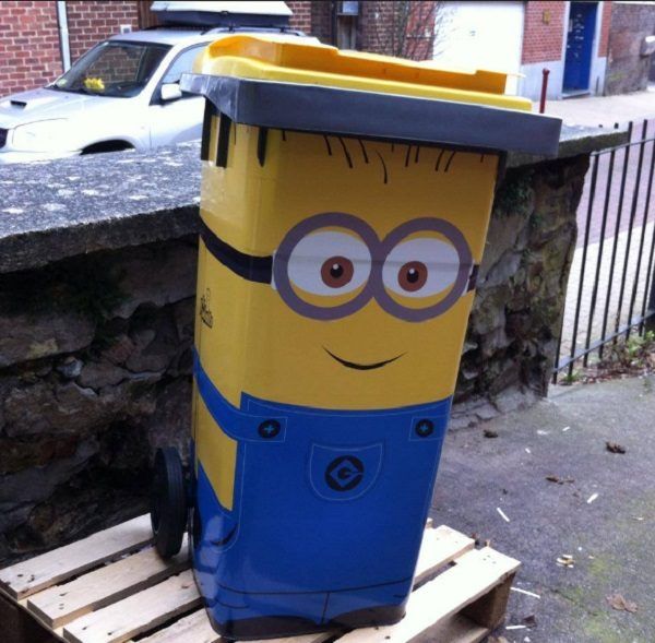 a yellow and blue trash can sitting on top of a wooden pallet