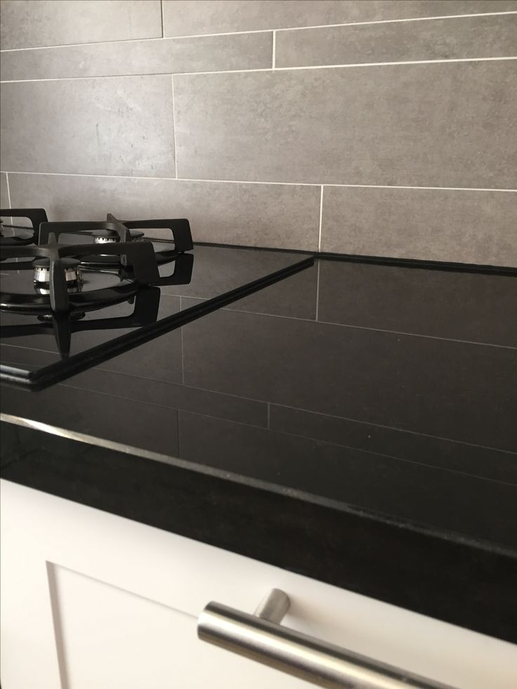 a black stove top sitting inside of a kitchen next to a white counter top oven