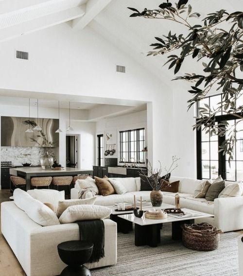 a living room filled with furniture and a large tree in the middle of the room