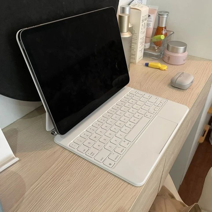 a laptop computer sitting on top of a wooden desk