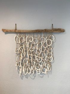 a wall hanging made out of wood and rope with letters on it's side