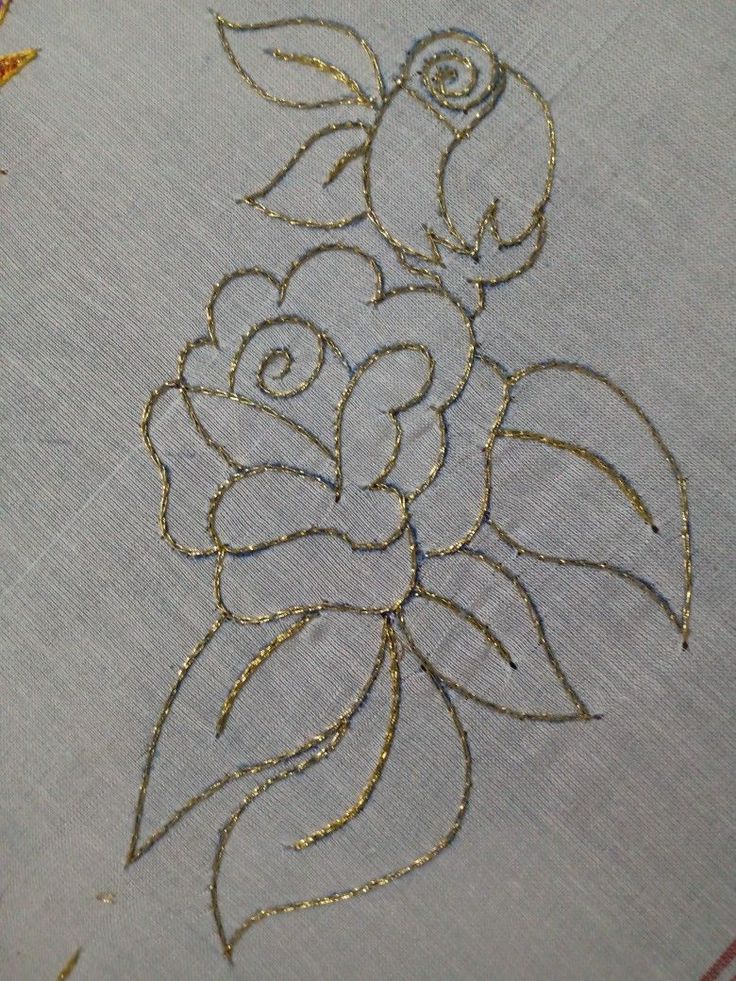 a close up of a piece of cloth with gold thread on it and some flowers