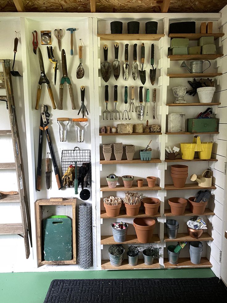 a room filled with lots of pots and gardening utensils hanging on the wall