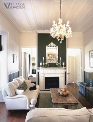 a living room filled with furniture and a fire place under a chandelier hanging from the ceiling