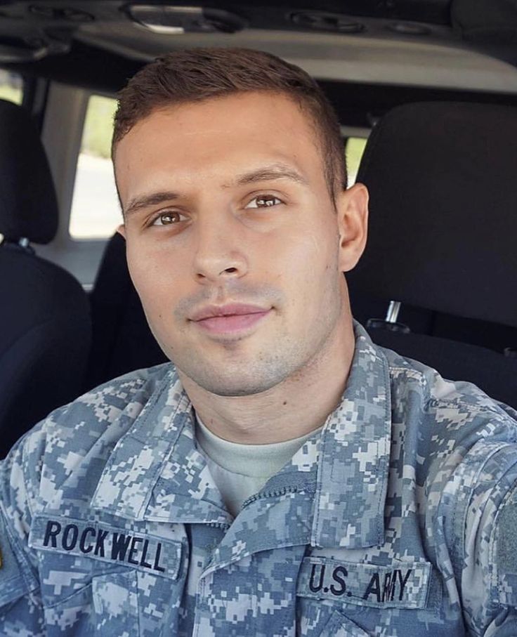 a man in uniform sitting in the back seat of a car