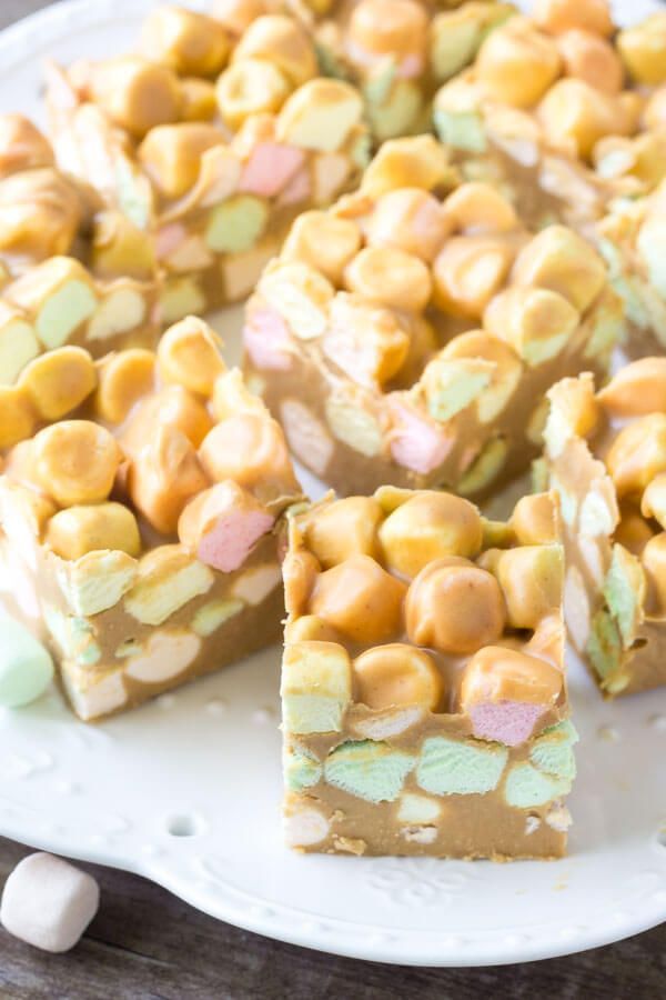 a white plate topped with pieces of cake next to marshmallows