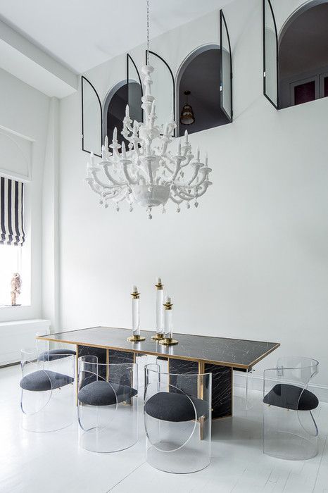 an elegant dining room with white walls and black chairs