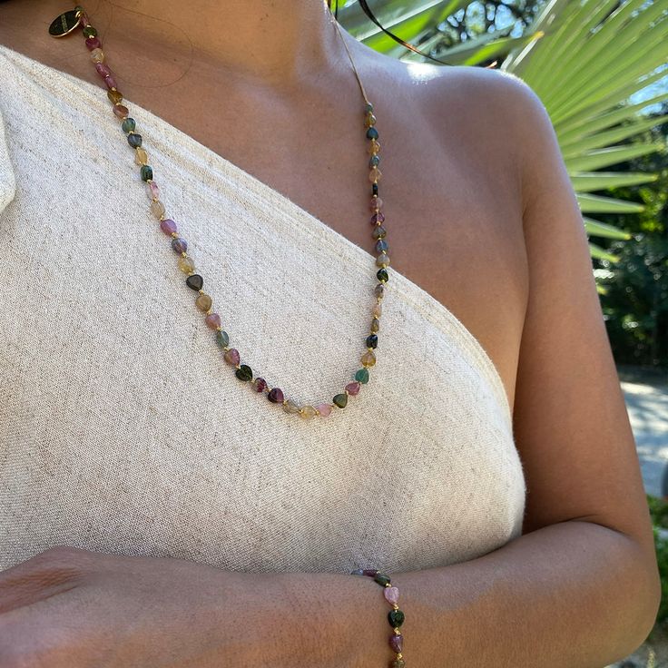 Wear our new tourmaline heart stone necklace and feel the power of Tourmaline's calming energy. This beautiful bracelet will be a constant reminder of the positive vibrations that Tourmaline brings. It will keep you balanced and grounded, while providing protection against bad vibes. Handmade with LOVE by talented artisans in Bali, Indonesia, so you may observe slight variations in color Multicolored Tourmaline heart-shaped beads Adjustable length for choker and princess look 16" extends to 18" Healing Tourmaline Gemstone Bead Necklaces, Spiritual Tourmaline Gemstone Beads Jewelry, Bohemian Tourmaline Round Bead Necklaces, Bohemian Tourmaline Bead Necklaces, Spiritual Tourmaline Gemstone Bead Necklaces, Adjustable Tourmaline Gemstone Necklace, Spiritual Tourmaline Gemstone Bead Necklace, Healing Tourmaline Gemstone Necklace, Tourmaline Necklace With Natural Stones And Round Beads