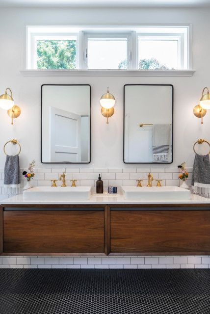 a bathroom with two sinks and mirrors above them in front of a window on the wall