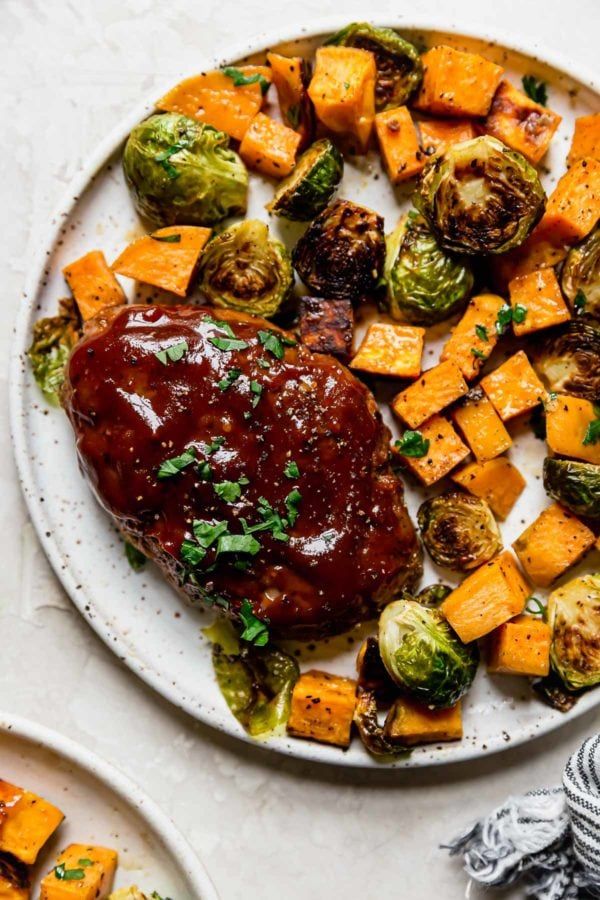 a white plate topped with brussel sprouts and sweet potatoes