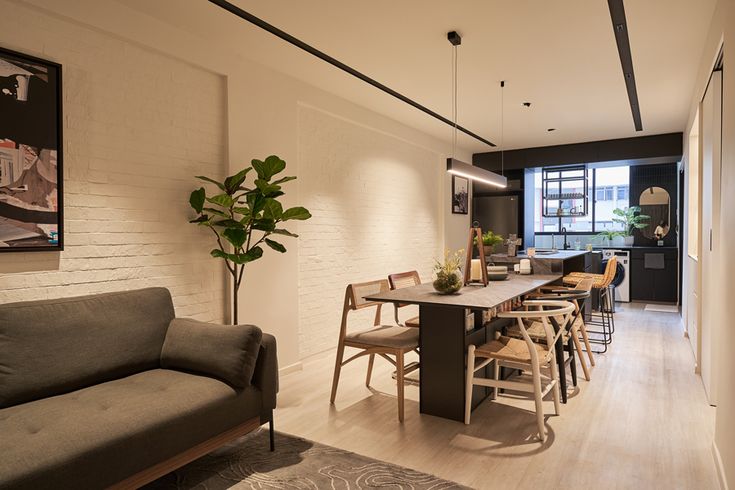 a living area with a couch, dining table and kitchen in the backround