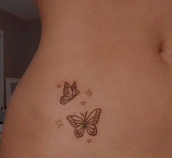 a woman's stomach with two butterflies on it