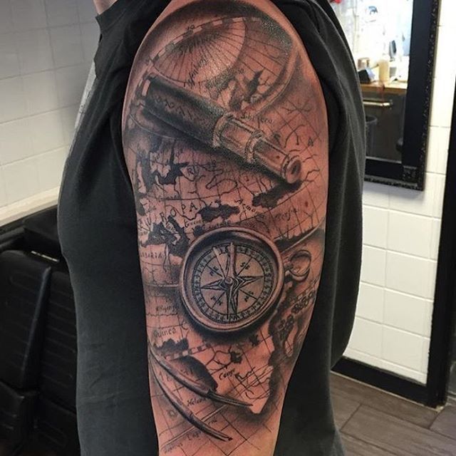 a man with a tattoo on his arm has a map and a compass in it