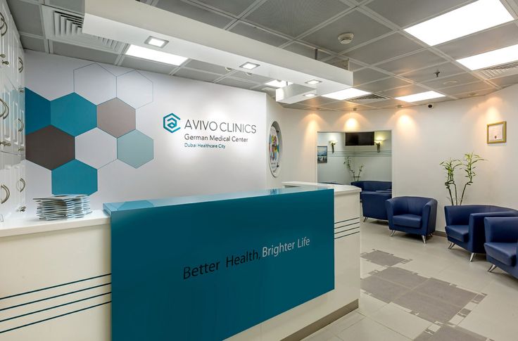 the front desk of an office with blue chairs around it and a sign that says better healthier life