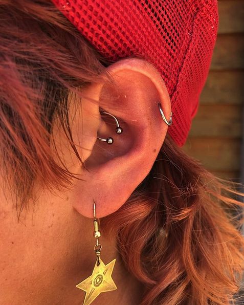 a close up of a person wearing ear piercings