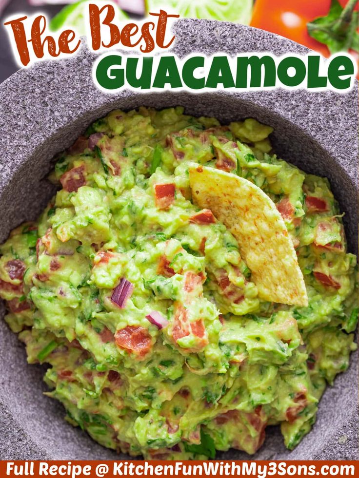 a bowl filled with guacamole and tortilla chips on the side