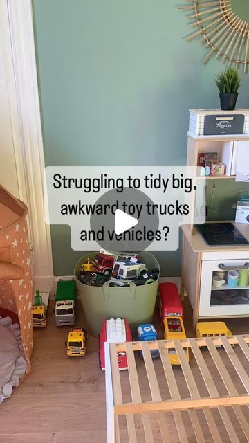 a child's bedroom with toy trucks and toys on the floor next to it