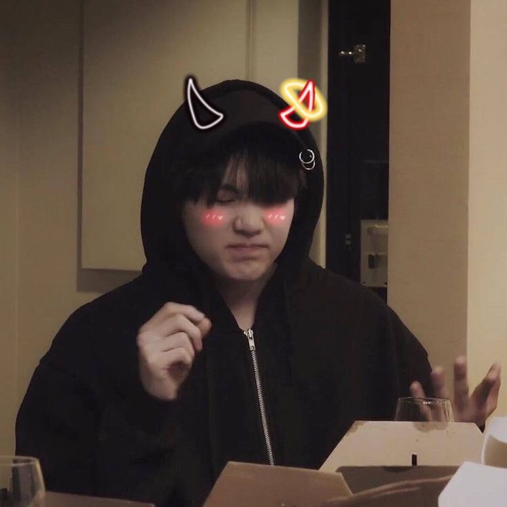 a person wearing a cat ears hoodie in front of a table with boxes and cups