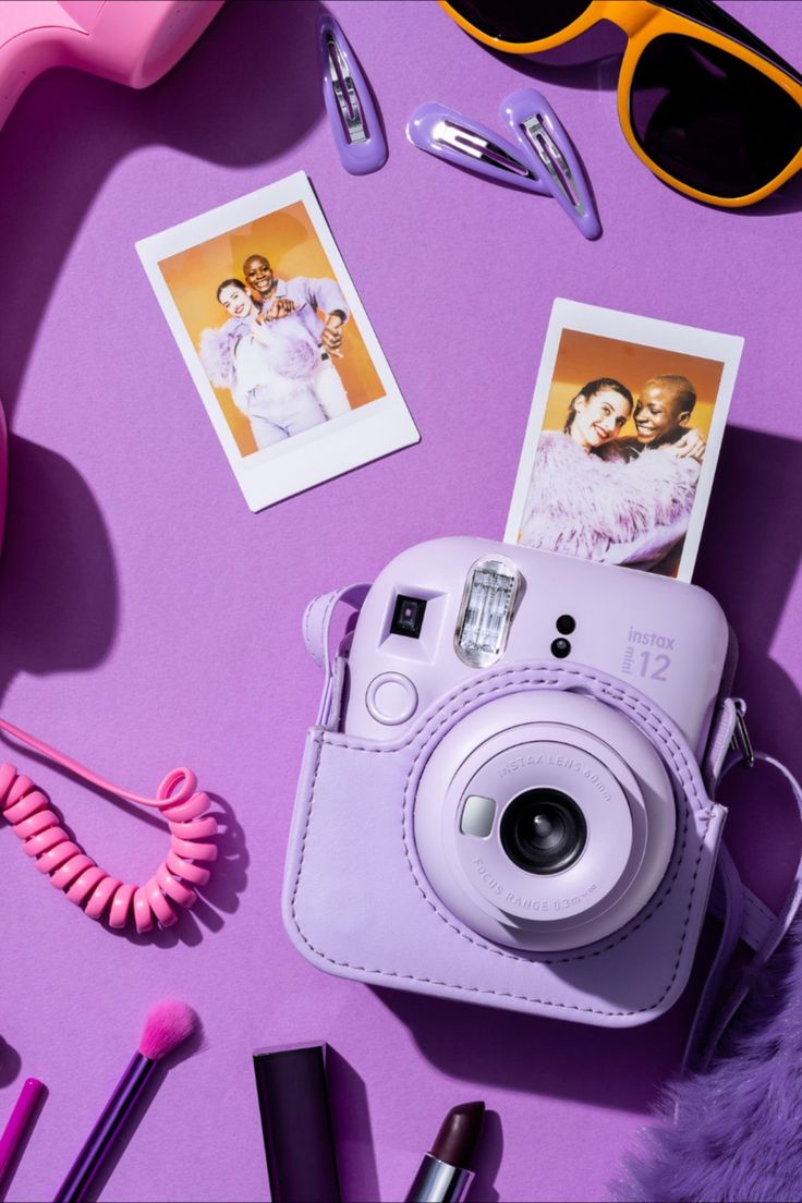 a camera and other items on a purple surface