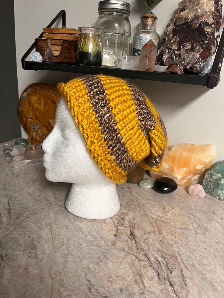 Hand stitch with heart, this slouchy beanie is the perfect blend of soft and thick.  A beautiful blend of yellow and variegated brown yarn, it's perfect for staying cozy on cold days.  -Slouchy Style -Adult Size Small -Hand knit & made in the U.S.A -Made with acrylic yarn -Fits head circumference 20in -Hand wash cold with like colors and air dry. Handmade Yellow Crochet Hat For Winter, Yellow Crochet Hat For Winter, One Size, Cozy Brown Crochet Hat With Soft Knit, One Size Yellow Crochet Hat For Winter, Winter Yellow Crochet Hat, One Size, Casual Yellow Crochet Beanie Hat, Casual Yellow Crochet Beanie, Winter Yellow Crochet Hat, Brown Chunky Knit Cozy Beanie