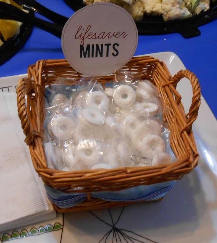 a basket filled with white donuts sitting on top of a table next to other food