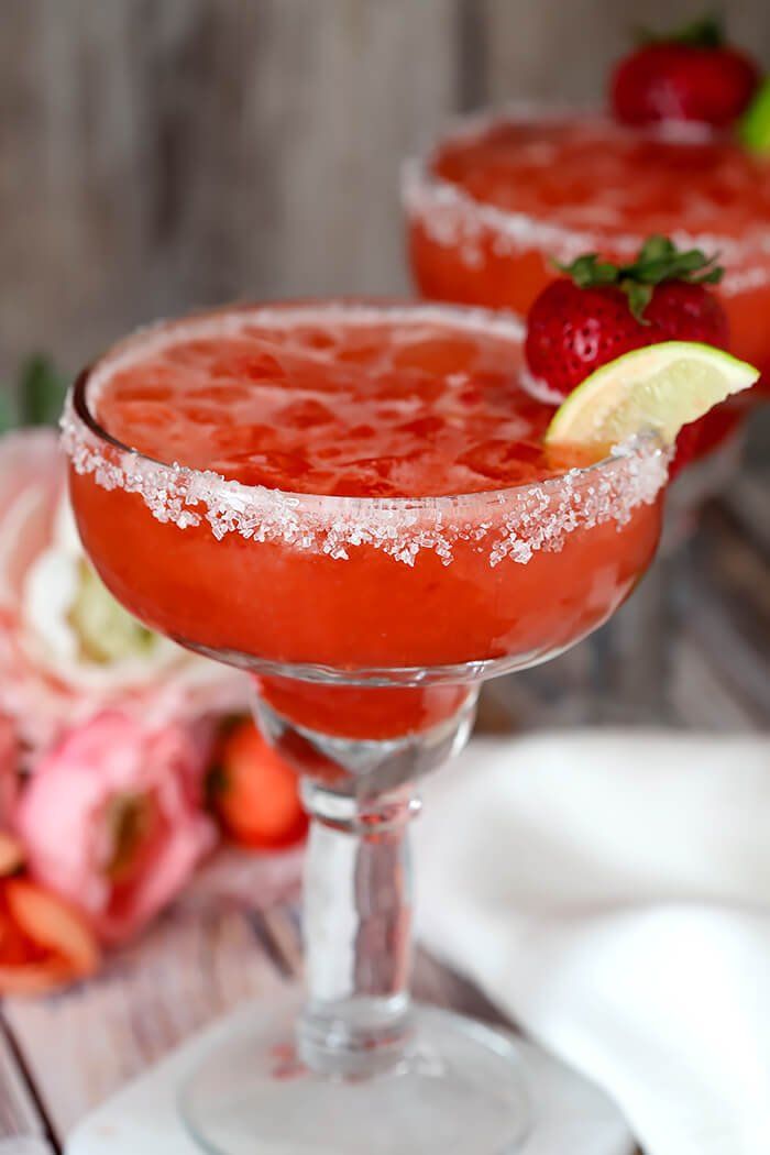 strawberry lemonade margarita cocktail recipe with sugar on the rim and garnished with fresh strawberries