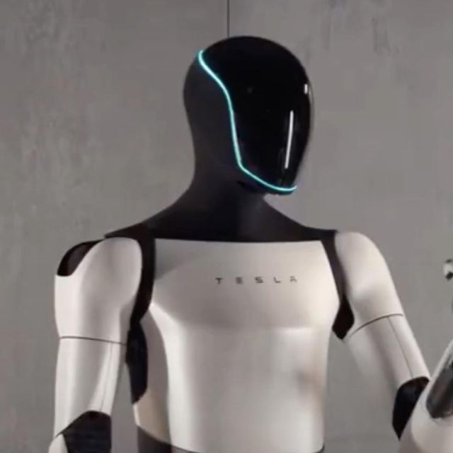 a robot is holding a cell phone in his right hand and looking at the camera