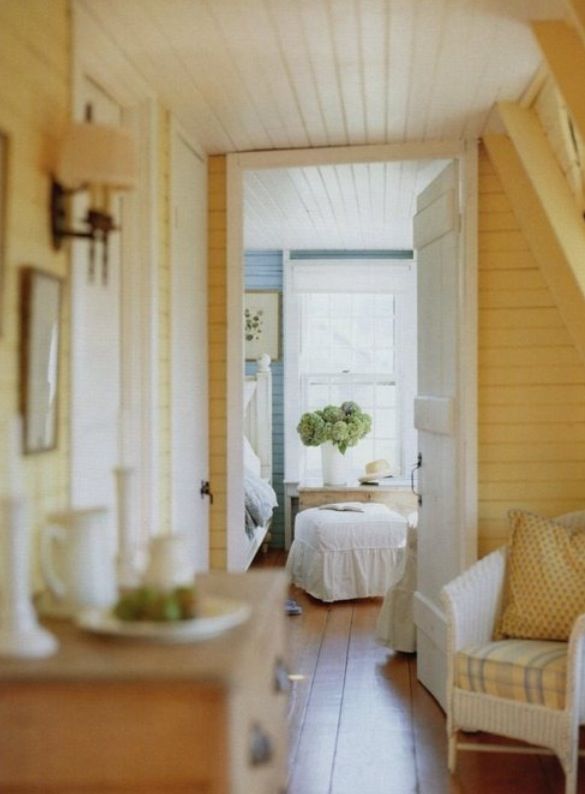 a room with yellow walls and white furniture