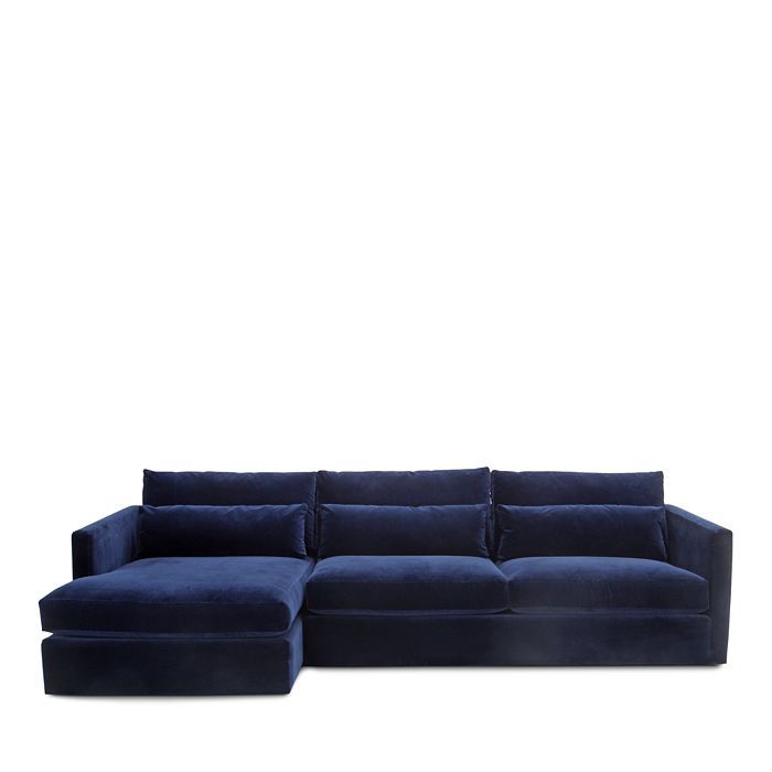 a blue sectional couch sitting on top of a white floor