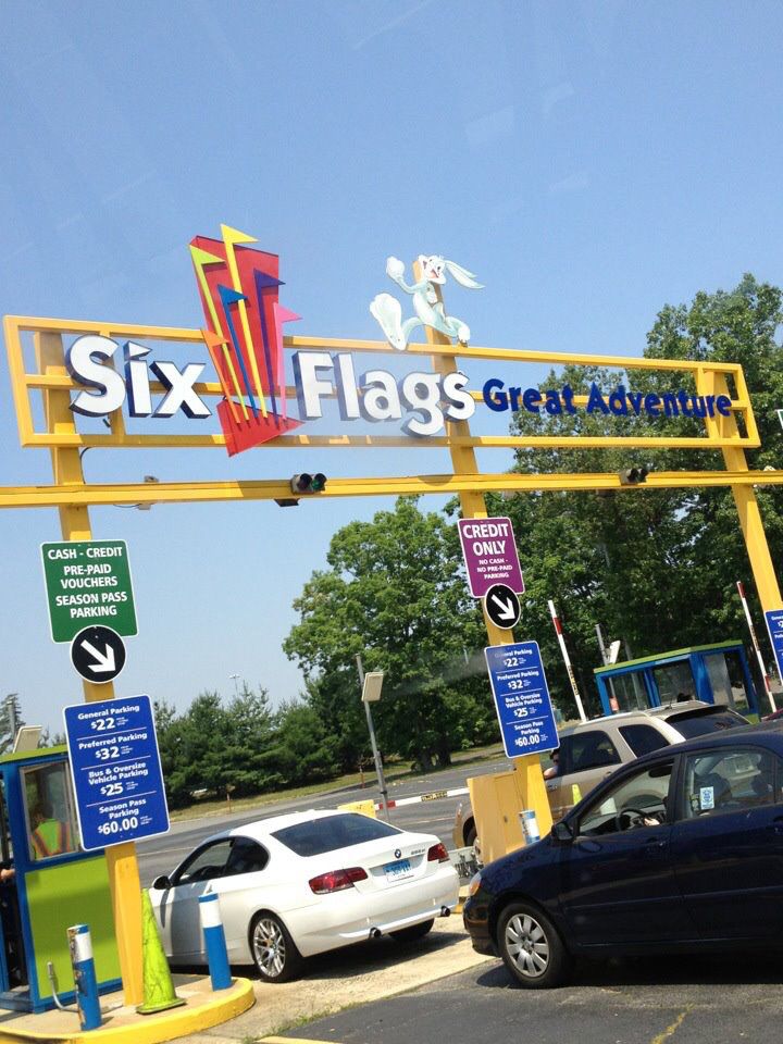 cars are parked in front of the six flags great adventure sign and gas station entrance