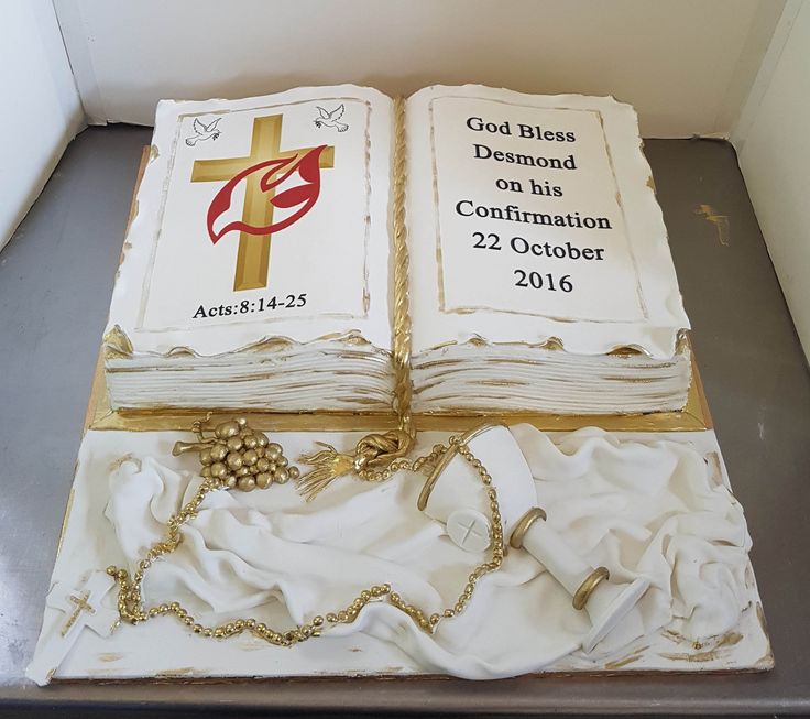 the cake is made to look like two books with rosarys on them and gold chains