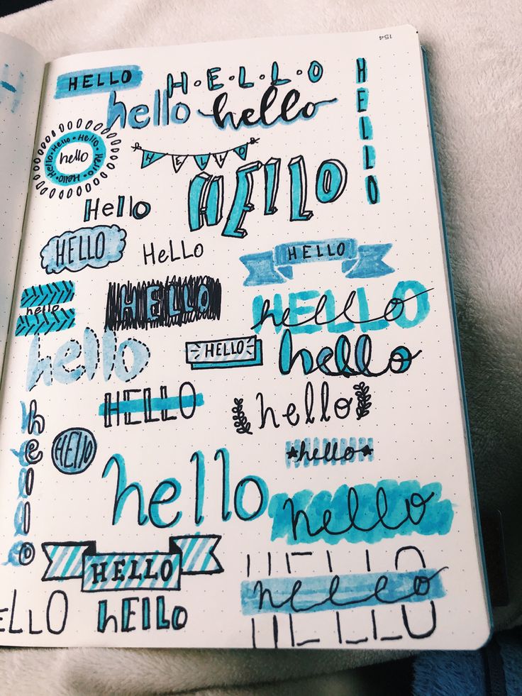 an open notebook with writing on it and some blue ink in the pages that read hello hello