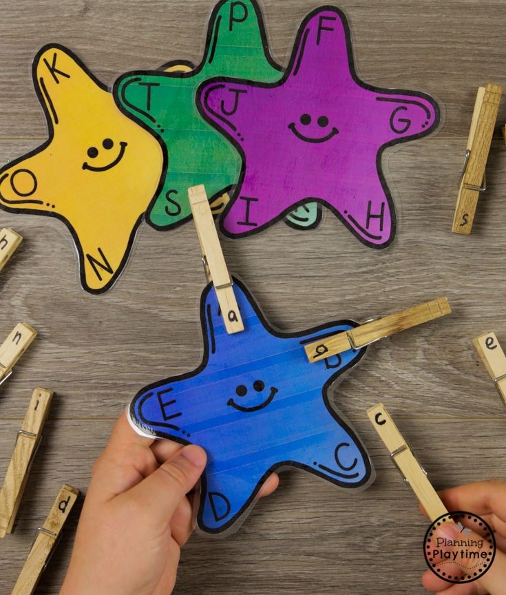 someone is playing with wooden clothes pegs and starfish puzzles on the table in front of them