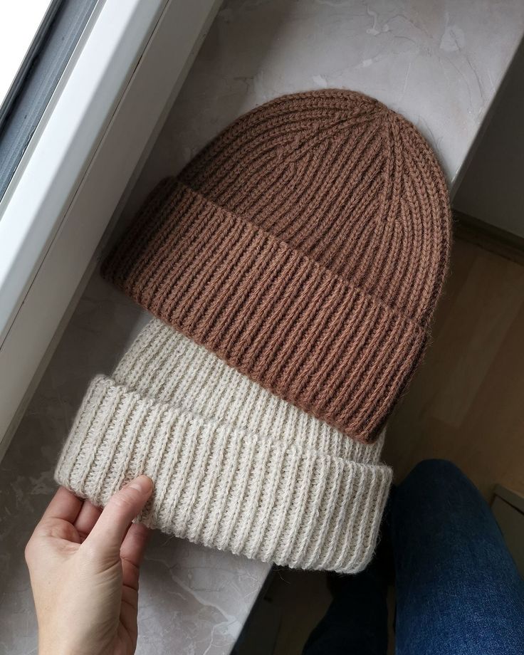 a person is holding onto a beanie hat