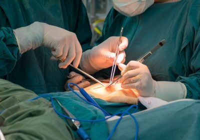 two doctors performing surgery on an injured patient