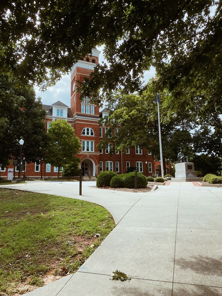 a large building with a clock tower in the middle of it's front yard