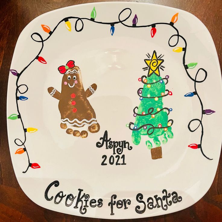 a white plate with a christmas tree and a gingerbread cookie for santa on it