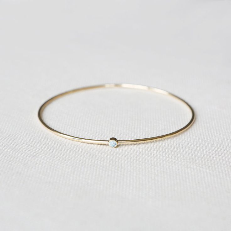 The Birthstone Bangle Yellow Gold - Round – Yearly Company Dainty Everyday Jewelry With Smooth Bezel, 14k Gold Bangle With Bezel Setting, Minimalist Jewelry With Smooth Bezel As Gift, Minimalist Jewelry With Smooth Bezel For Gifts, Minimalist Jewelry With Smooth Bezel Gift, Minimalist Adjustable Jewelry With Smooth Bezel, 14k Gold Birthstone Hoop Jewelry, Dainty Yellow Gold Jewelry With Smooth Bezel, Dainty 14k Gold Jewelry With Smooth Bezel