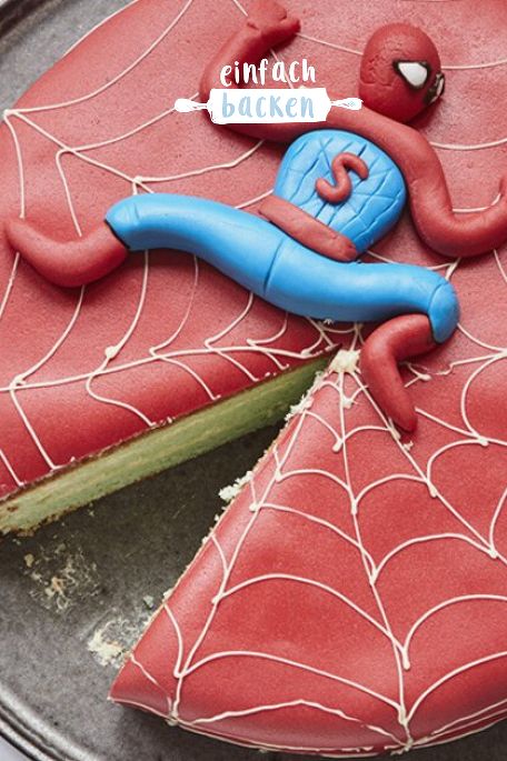 a spider - man cake is decorated with icing and sprinkles on a plate