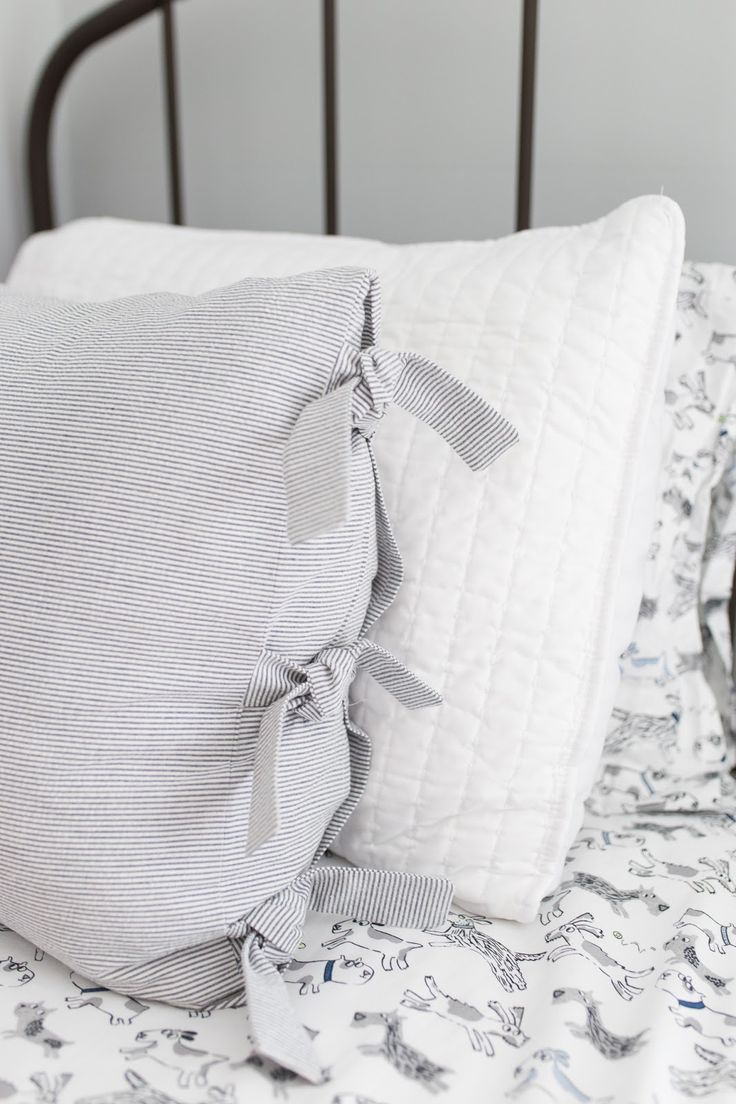 a bed with two pillows on top of it next to a pair of eyeglasses