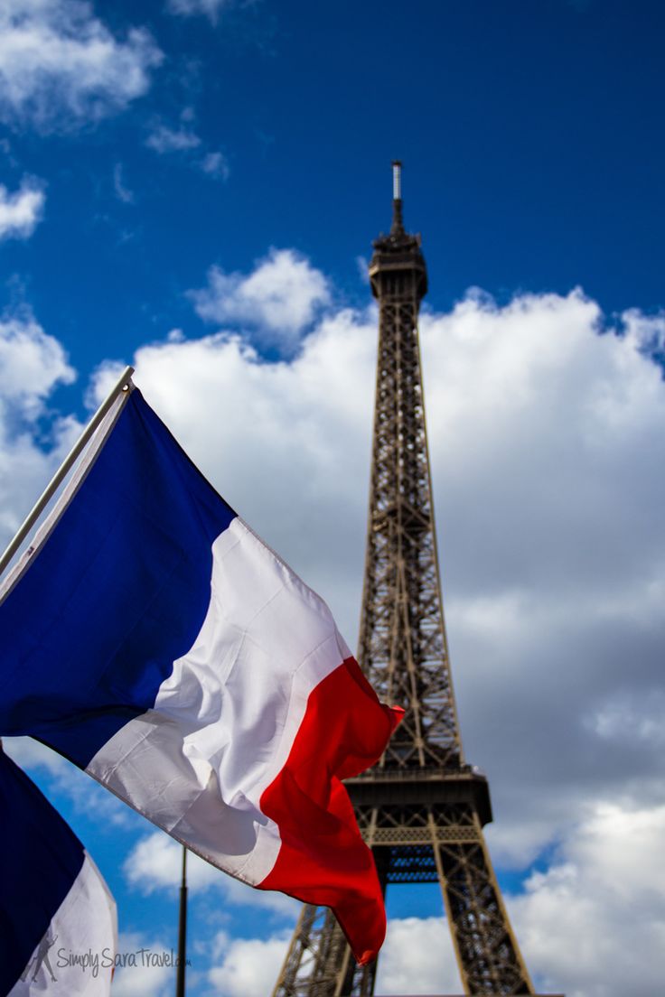 the eiffel tower in paris, france with a flag flying next to it