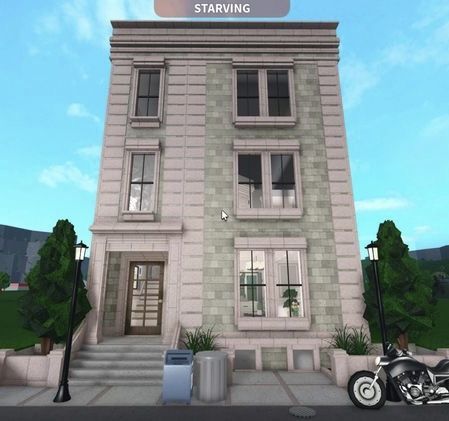 a motorcycle is parked in front of a tall building with stairs leading up to it