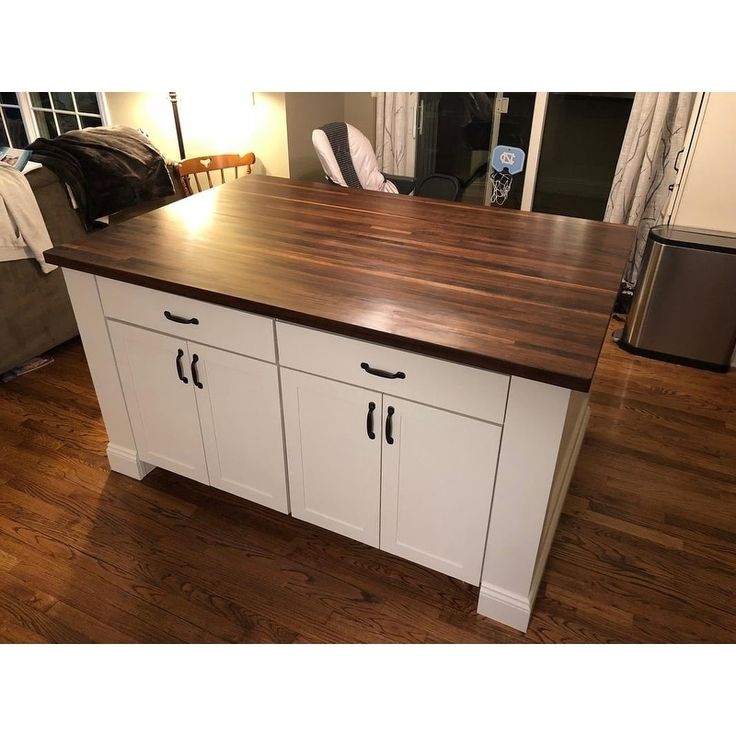 a kitchen island made out of wood and white cabinets