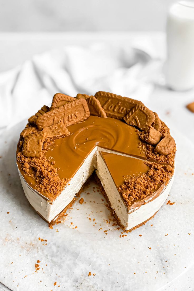 a cake that has been cut into pieces and is sitting on a white plate with a glass of milk in the background